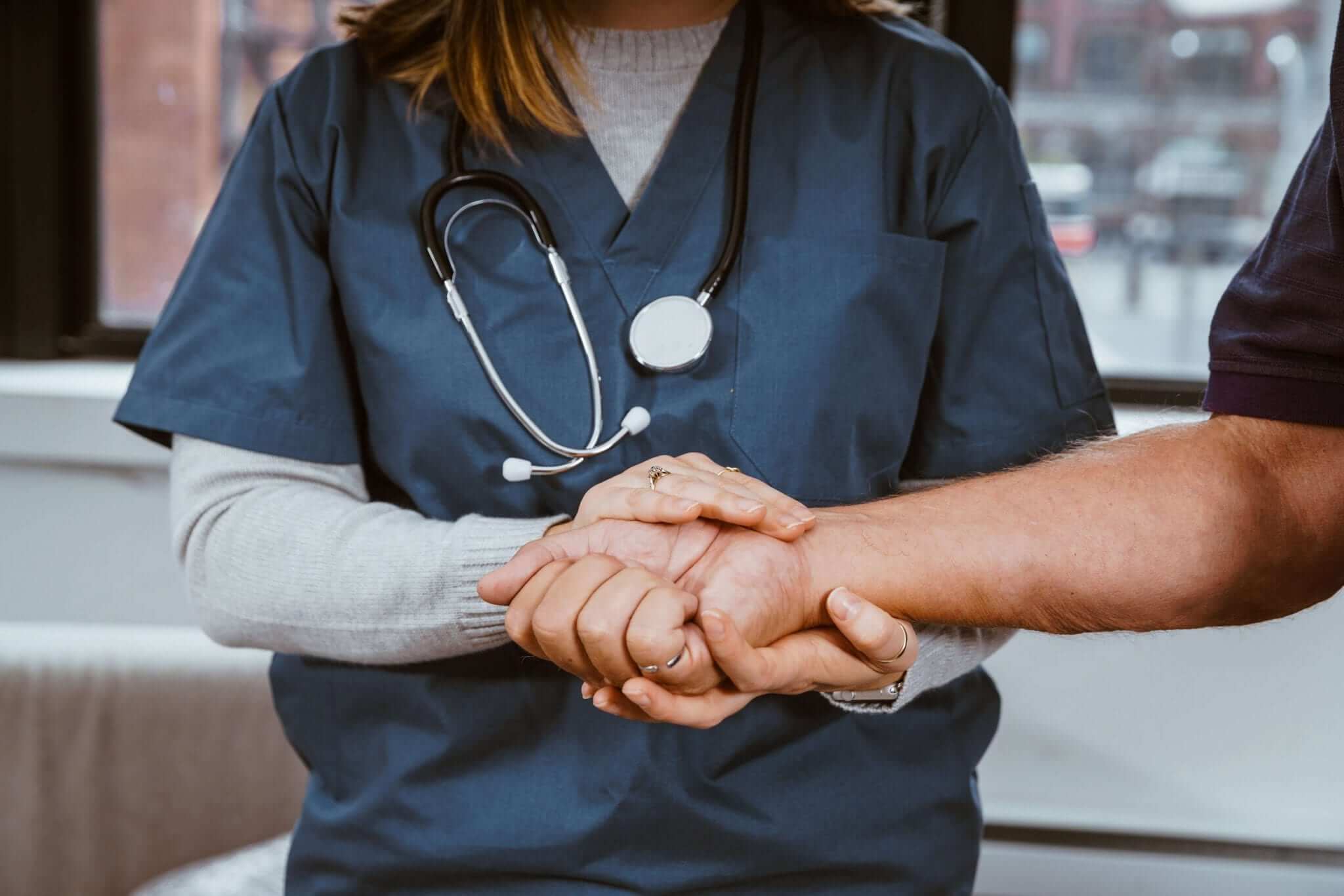 Licensed Vocational Nurse (LVN) Holds Hand of Patient
