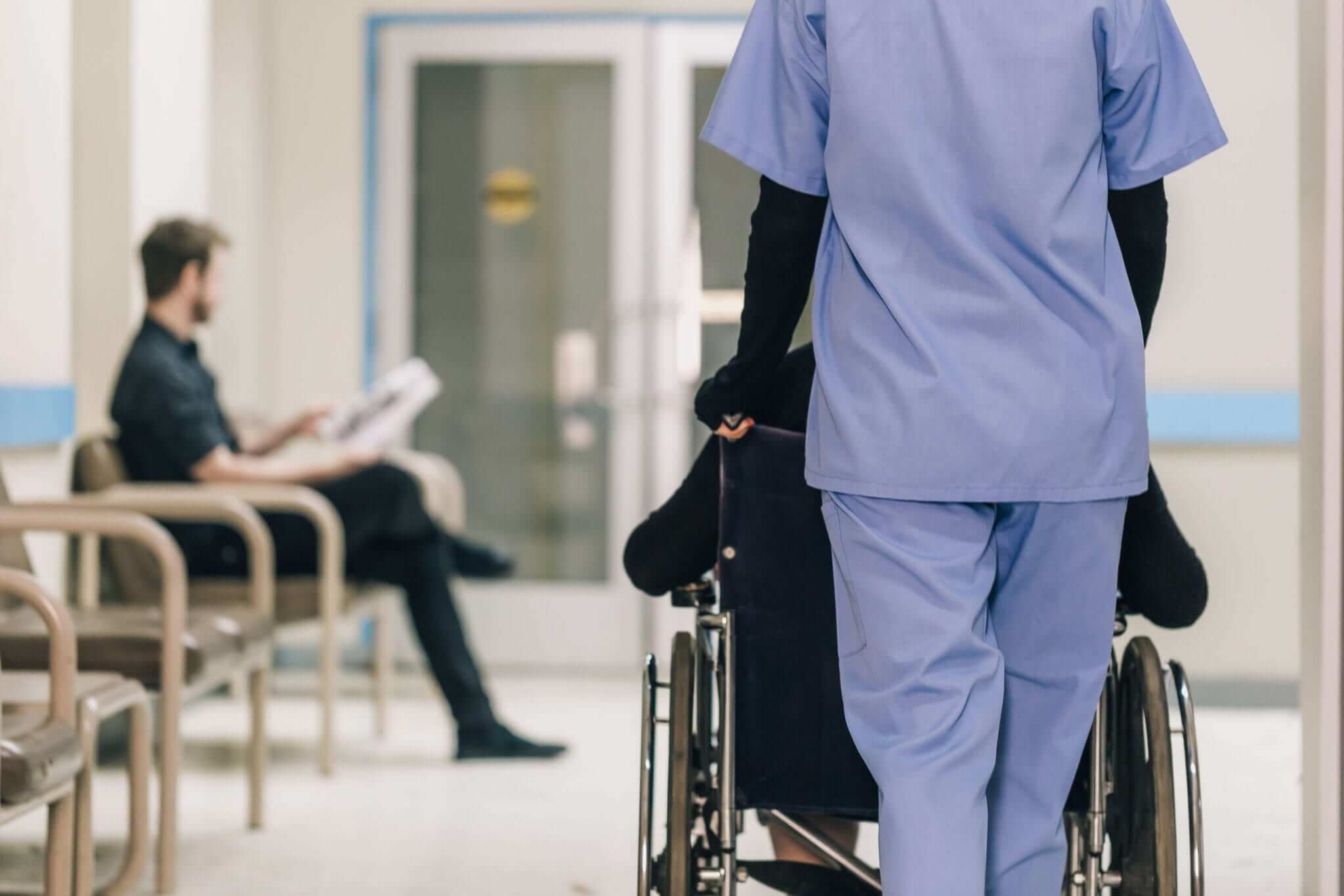The LPN Wheels a Patient Down Hospital Hallway